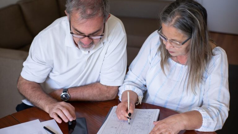 Taking pension money early can store up trouble for the future Taking pension money early can store up trouble for the future: an older couple going through pension and retirement paperwork together at home